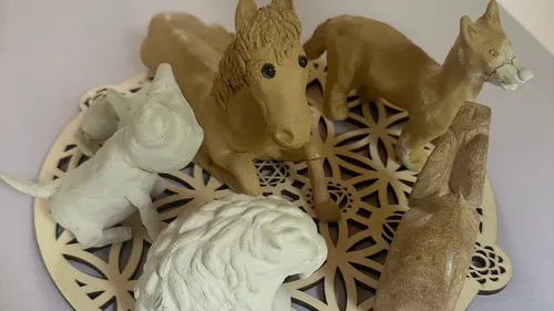 Animal figurines on decorative wooden plate.