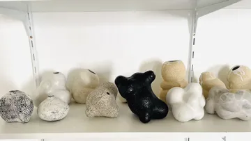 Ceramic figures displayed on a white shelf.