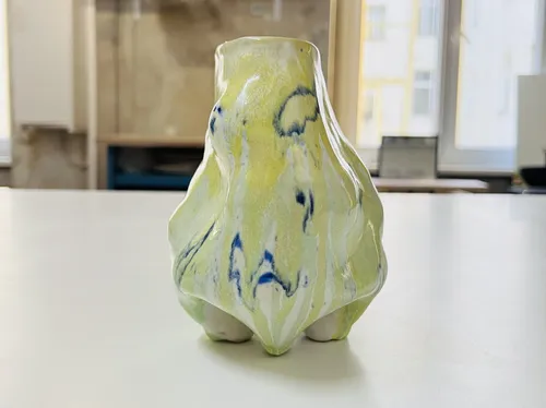 Keramikvase mit abstraktem Muster auf Tisch.