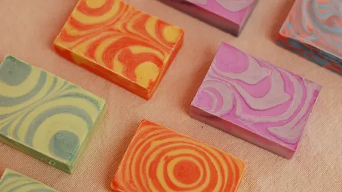 Colorful soap bars on beige surface.