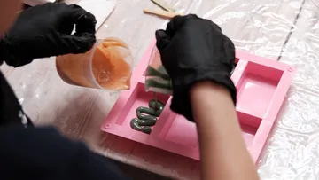 Person pouring liquid into a silicone mold.