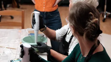 People using hand blenders in kitchen.