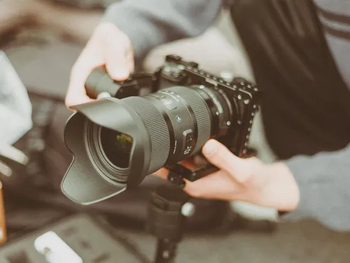 Camera in hands, ready to shoot, environment blurred.