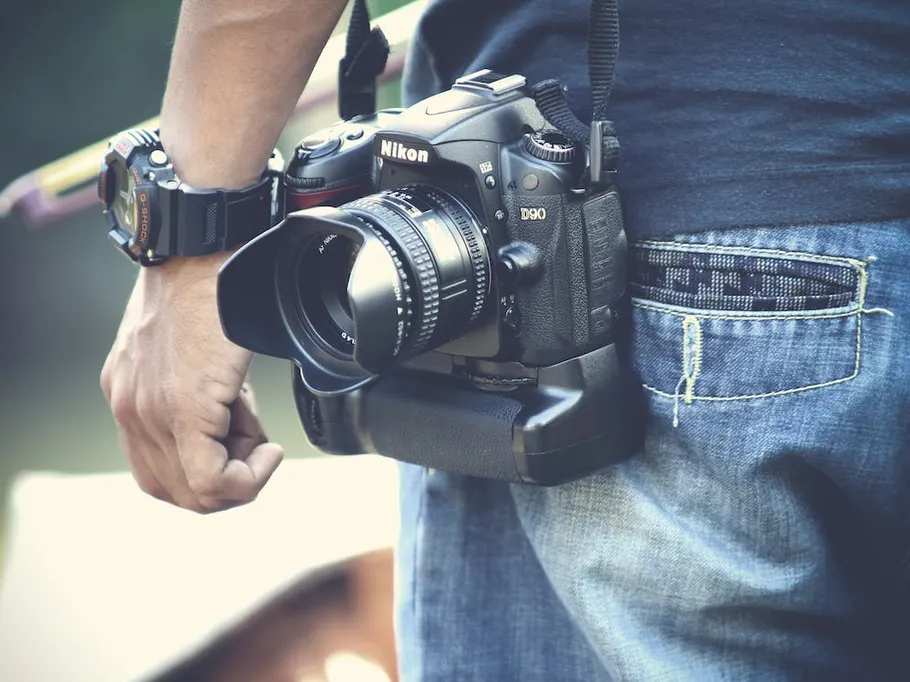 Camera hangs on the hip of a person wearing jeans.