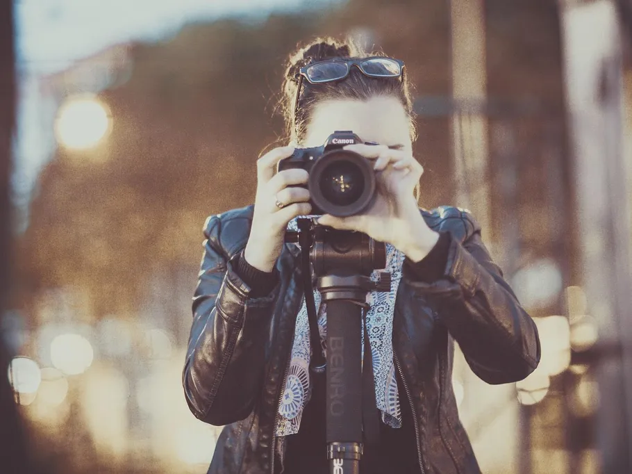 A person takes pictures with a camera in the city.