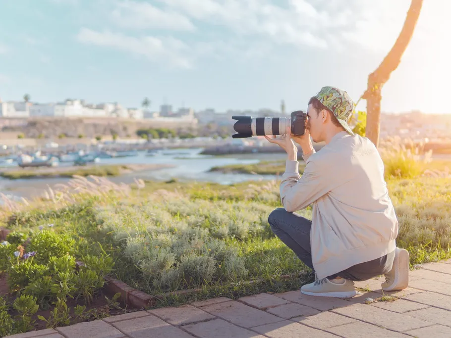 Person fotografiert Landschaft mit Kamera im Freien.