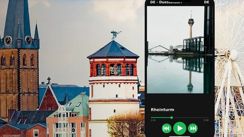 Smartphone zeigt Rheinturm vor Stadtansicht.