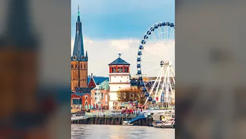 Kirchturm und Riesenrad am Fluss