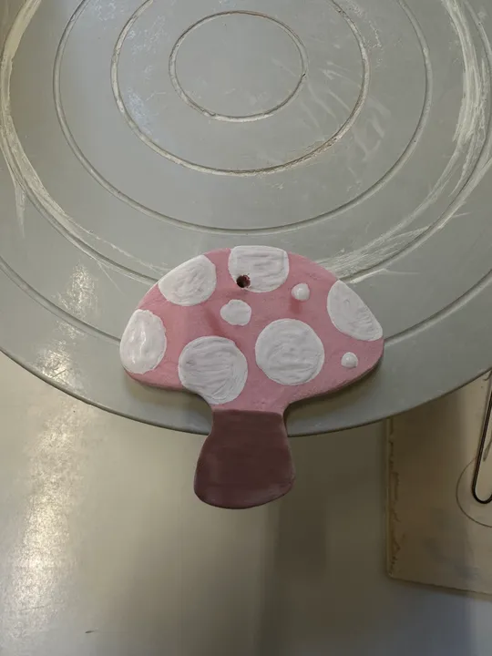 Rosa Pilzskulptur auf Töpferscheibe.