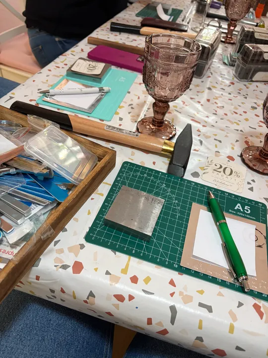 Bastelwerkzeuge auf gesprenkelter Tischdecke.