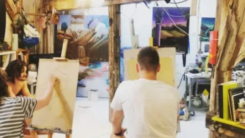 Artists drawing in a vibrant studio.