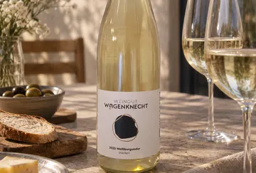 Wine bottle on table with snacks.