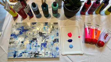 Acrylfarben und abstrakte Leinwand auf Tisch.