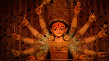 Goddess statue with multiple arms, holding various items.