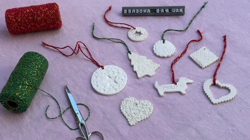 Tonschmuck mit Fäden auf Stoff.