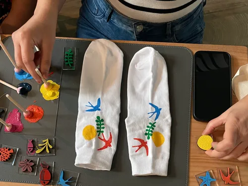 Hände bemalen Socken auf einem Tisch.