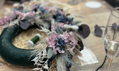 Floral wreath with colorful flowers on table.
