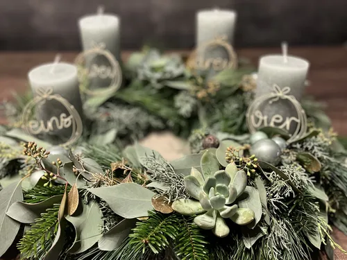 Advent wreath with candles on wooden table.