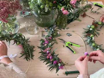 Flowers are arranged into wreaths on a table.