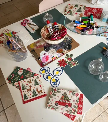 Bastelmaterialien auf Tisch verteilt, Weihnachtsmotive.