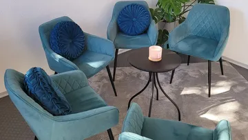 Chairs arranged around a small table, indoor setting.