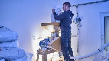 Man filling machine with large bag indoors.