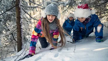 Kinder kriechen im verschneiten Wald.