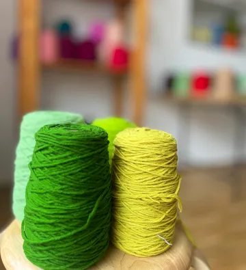 Bunte Garnspulen auf Holzoberfläche.