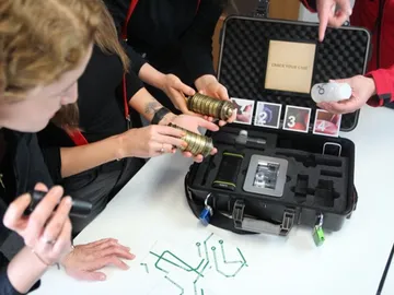 Group members solve puzzles using a luggage case and objects.