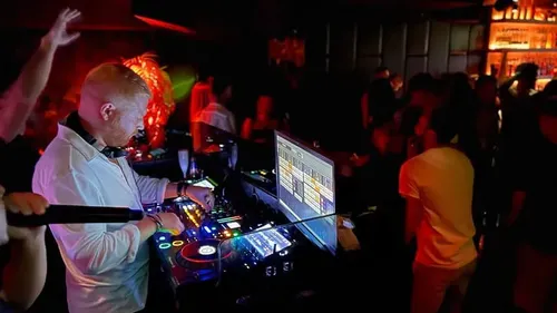 DJ playing music at nightclub party.
