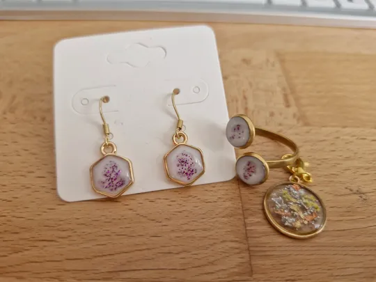 Schmuckset mit Ohrringen und Ringen auf Holz.