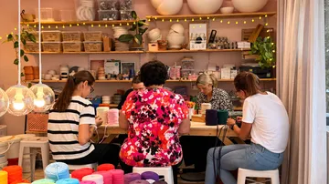 People crafting with yarn in a workshop.