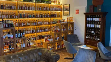 Shelves filled with liquor bottles in a cozy bar.