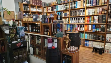 Whiskey bottles displayed on wooden shelves.