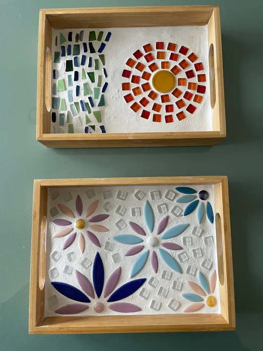 Two wooden trays with colorful mosaic designs.
