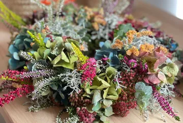 Blumenkranz auf Holztisch liegend.