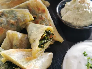 Frittierte Teigtaschen mit Gemüse, serviert mit Dips.