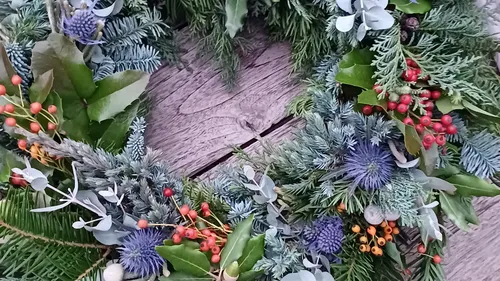 Festive wreath with berries on a table.