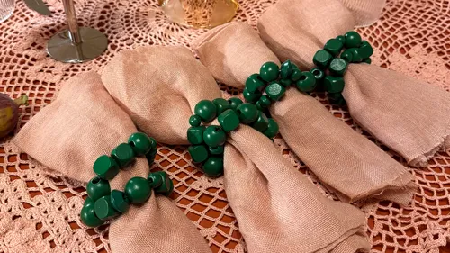 Servietten mit grünen Ringen auf Spitzentischdecke.