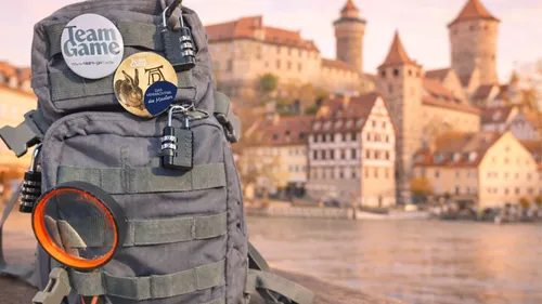 Rucksack mit Abzeichen, Stadtansicht im Hintergrund.