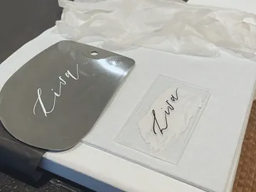 Hand mirror and card with the name `Lisa` on support.