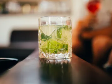 Ein Glas mit einem Getränk steht auf einem Tisch.