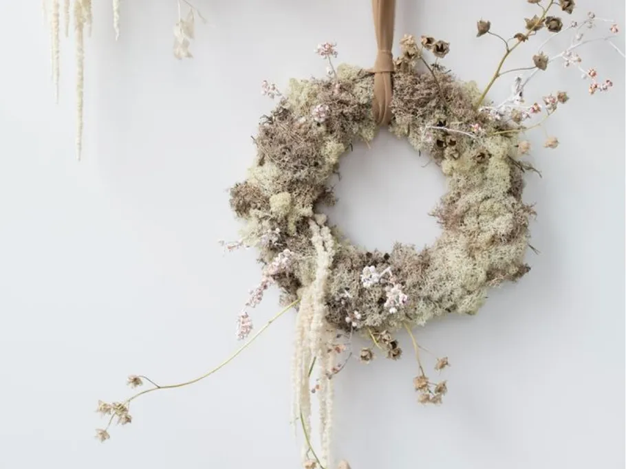 Circular wreath of dried plants on a wall.