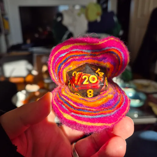 Hand hält bunte Würfel in hellem Raum.