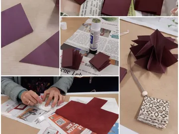 Papier wird gefaltet und geklebt, um Dekoration zu erstellen.