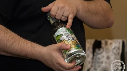 Mann hält Tequilaflasche drinnen.