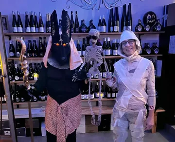 Zwei verkleidete Personen mit Requisiten im Weinladen.