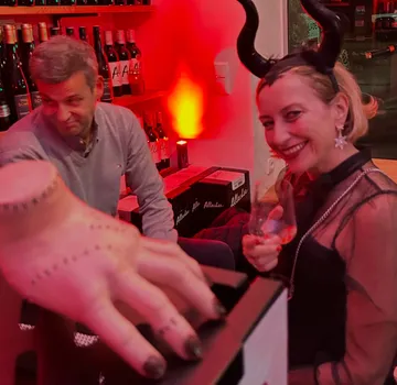 Person mit Hörnern lächelnd, sitzt auf Party.
