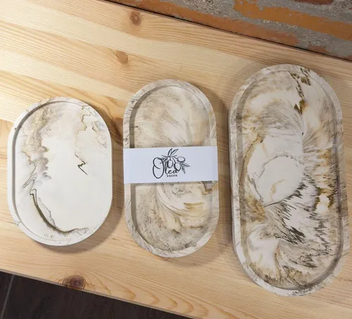 Three decorative trays on wooden table.