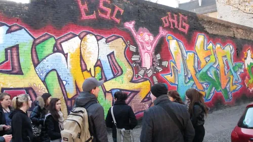 Graffiti auf Ziegelwand, Menschen beobachten.